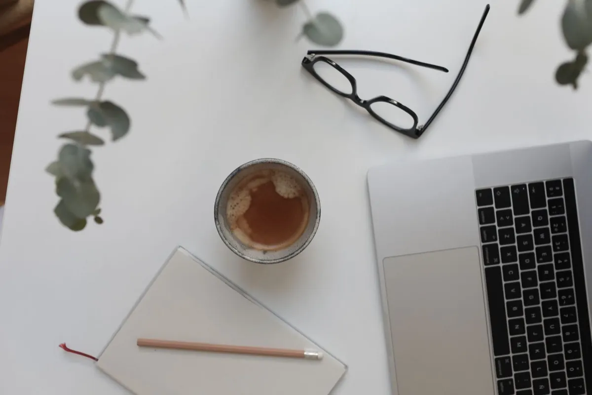 Pracovní stůl s&nbsp;notebookem, kávou a&nbsp;zápisníkem, plánování webu pro živnostníka
